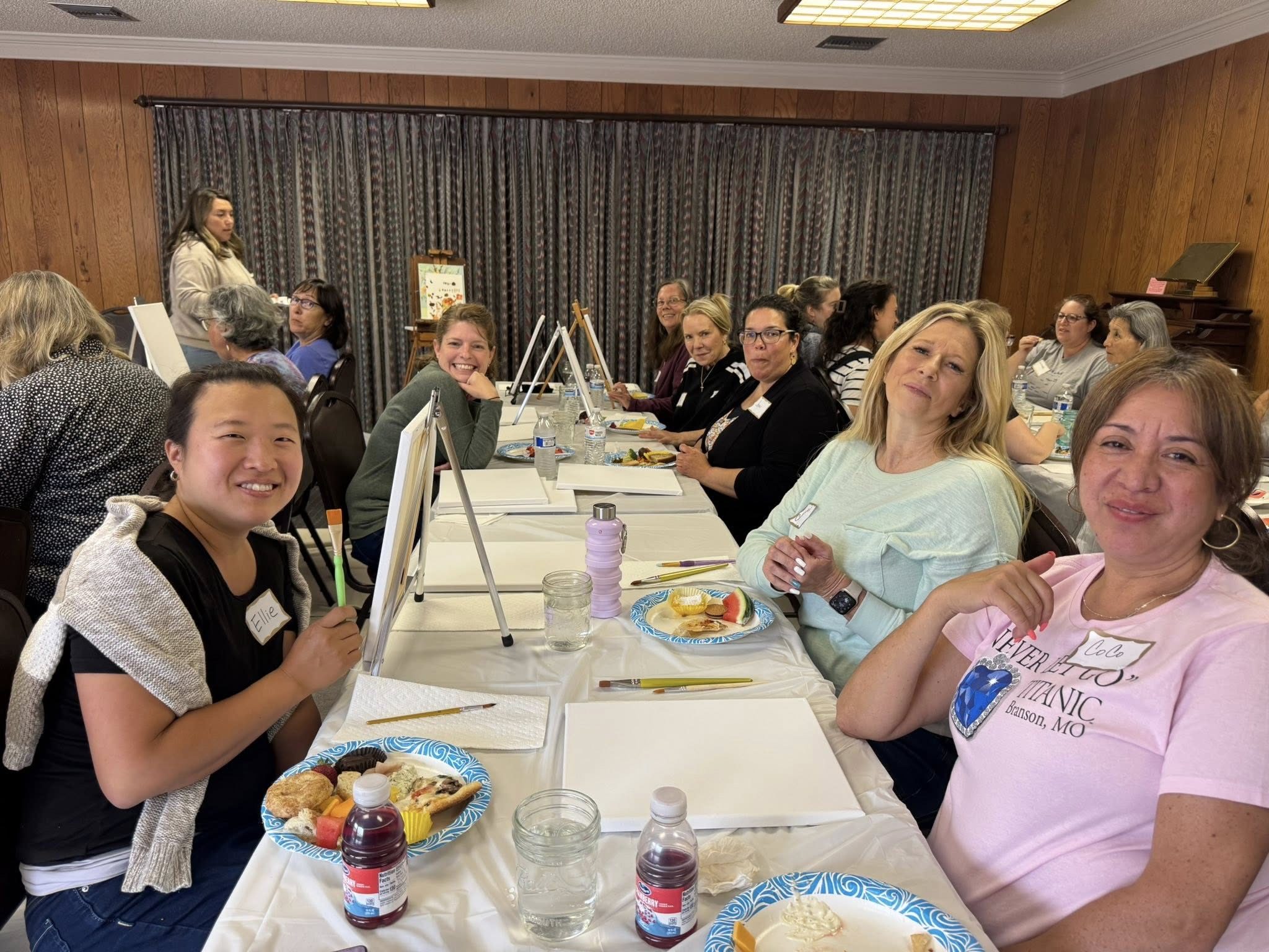 Women of ONE paint-night fellowship around a long table at FBC Salinas