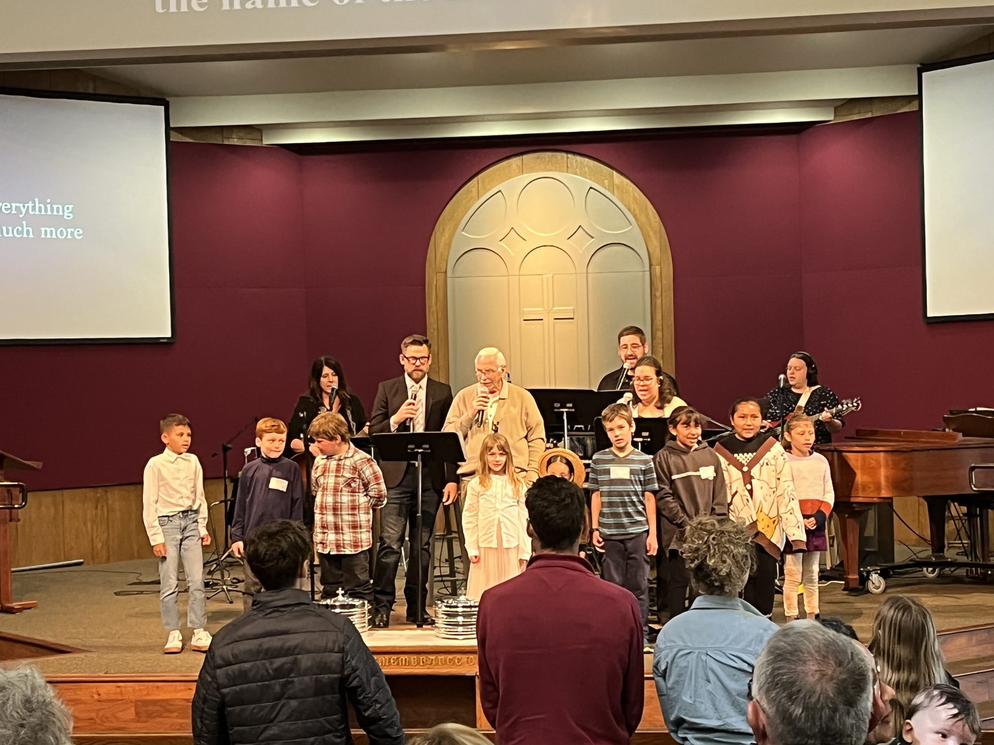 Children standing with worship leaders on the sanctuary stage